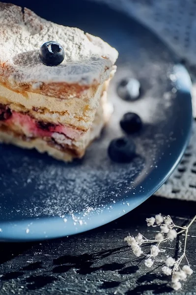 Sweet cakes with berries on blue flat