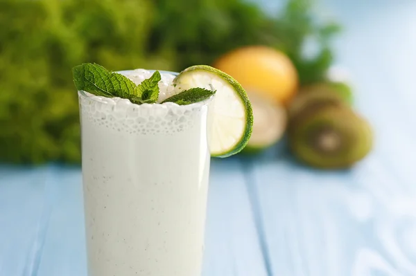 Conceito de alimentação saudável. batido de leite em vidro e legumes verdes frescos — Fotografia de Stock