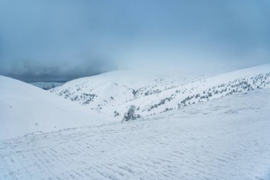 Harika bir kış manzarası. Karla kaplı dağlar ve mavi bulutlu gökyüzü