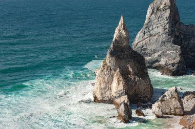 Atlantik Okyanusu manzaralı güzel bir ufuk, kumlu bir sahil, gün doğumunda kayalar ve dalgalar. Ursa Sahili, Sintra, Portekiz