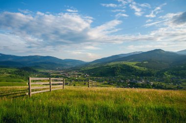 Ufukta yüksek dağ köyü ve mavi bulutlu gökyüzü ile harika bir manzara. Yaz manzarası. güzel doğal arkaplan
