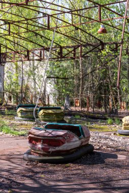 Old broken radioactive  cars in amusement park. the most famous ghost town Pripyat near Chernobyl and Nuclear Power Plant. exclusion zone. Ukraine. clipart