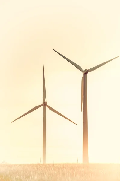 Silueta vintage de un molino de viento en un campo rural al atardecer, nat — Foto de Stock