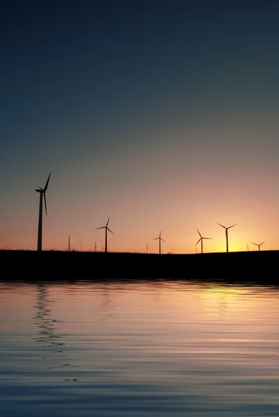 Silhouette di un mulino a vento al tramonto, sfondo naturale — Foto Stock