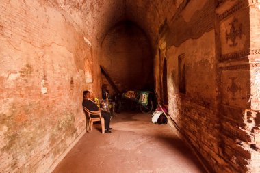 Malda, Batı Bengal, Hindistan - Ocak 2018: Gaur köyünde antik bir mozolenin karanlık bir koridorunda oturan bir adam.