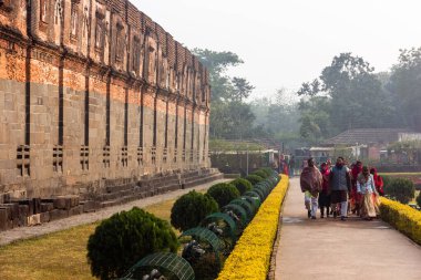 Malda, Batı Bengal, Hindistan - Ocak 2018: Pandua köyündeki antik Adina Mescidi camisinin kalıntıları önünde bahçelerde yürüyen bir grup turist.