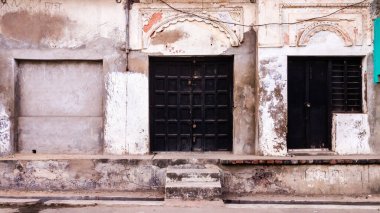 Murshidabad, Batı Bengal, Hindistan - Ocak 2018: Murshidabad kasabasındaki eski bir miras binasının kirli duvarlarında kapalı ahşap kapılar.
