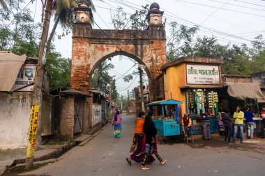 Murshidabad, Batı Bengal, Hindistan - Ocak 2018: Kadınlar eski Murshidabad kasabasının sokaklarında geçitten ve kadim kemerli kapılardan geçiyorlar.