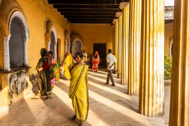 Murshidabad, Batı Bengal, Hindistan - Ocak 2018: Sarı sari giymiş bir kadın Murshidabad 'daki antik bir sarayda bir grup turistle tatilin tadını çıkarıyor.