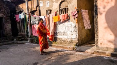 Kolkata, Batı Bengal, Hindistan - Ocak 2018: Kolkata şehrinin sokaklarında kırsal bir evin duvarlarında renkli bir sari giyen Hintli kadın.