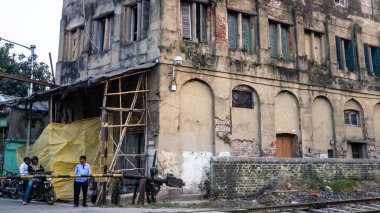 Kolkata, Batı Bengal, Hindistan - Ocak 2018: Kolkata kentinin Kumartuli bölgesinde eski bir kır evinin yanında bir demiryolu geçidi.