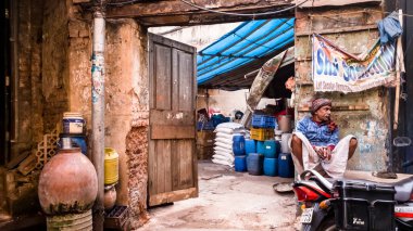 Kolkata, Batı Bengal, Hindistan - Ocak 2018: Kolkata kentindeki eski Barabazar bölgesinde bir evin kirli duvarlarının dışında oturan Hintli bir adam.