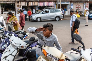 Mysuru, Karnataka, Hindistan - Ocak 2019: Kentin sokaklarında bisiklet aynasında gözlerini kontrol eden genç bir Hintli çocuk.
