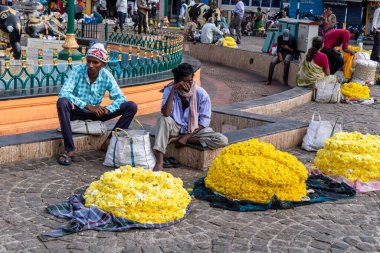 Mysore, Karnataka, Hindistan - Ocak 2019: Hintli sokak satıcıları Mysuru kentindeki bir pazar meydanında çelenk ve çiçek satıyorlar.