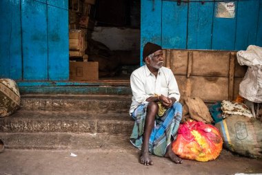 Mysore, Karnataka, Hindistan - Ocak 2019: Yaşlı bir Hintli, Mysuru şehrindeki Devaraj pazarının önünde düşünceli bir şekilde oturuyor..