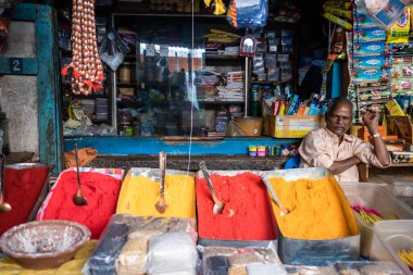 Mysore, Karnataka, Hindistan - Ocak 2019: Hintli bir esnaf, Gulal olarak da bilinen renkli toz satıyor..