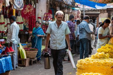 Mysore, Karnataka, Hindistan - Ocak 2019: Hint bir adam Mysore şehrindeki kalabalık bir pazarda matara ve köpük bardaklarda çay satıyor.