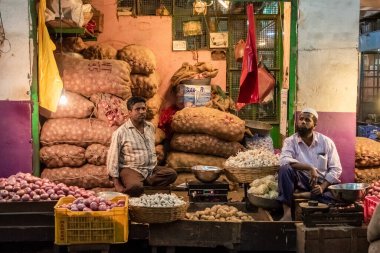 Bangalore, Karnataka, Hindistan - Ocak 2019: Bengaluru kentindeki eski KR market kompleksi içindeki bir sebze dükkanının sahipleri.