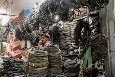 Bangalore, Karnataka, Hindistan - Ocak 2019: KR Market 'teki dükkanında lastik kablolar, kablolar ve endüstriyel ekipman satan Hintli bir esnaf.