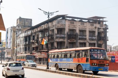 Mangalore, Hindistan - 19 Ocak 2023: Mangaluru şehrinde eski model mimari eserlerle dolu bir sokakta bir toplu taşıma otobüsü.