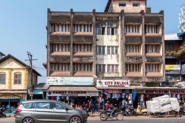 Mangalore, Hindistan - 18 Ocak 2023: Kentte işlek bir pazar caddesinde dükkanları olan eski pis bir bina.