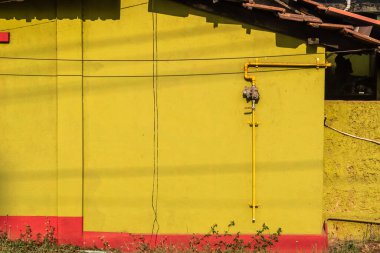 Mangalore, Hindistan - 18 Ocak 2023: Kırsal bir evin bej rengi duvarının yanında bir gaz boru hattı.