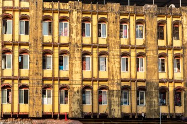 Mangalore, Hindistan - 18 Ocak 2023: Birçok kemerli penceresi olan eski ve pis bir binanın dış cephesi.