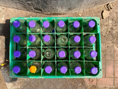 Mangalore, Hindistan - 16 Ocak 2023: Mor kapaklı cam içecek şişeleriyle dolu bir tepsinin üst açısı.