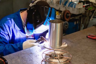 Fabrikada çalışan kaynakçılar metal üretiyorlar.