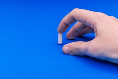 Tıbbi eldivendeki bir elin içinde bir paket hap var. Bir paket hapla el ele tutuşmak. Bir paket ilacı el ele tutuşarak. El ele tutuşan tıbbi ilaçlar