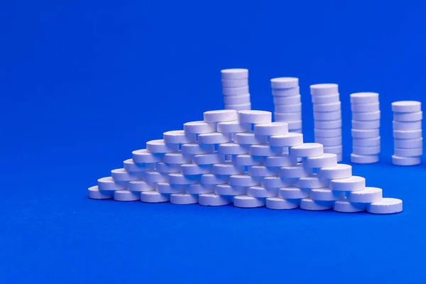 Close Piramide Concept Van Witte Pillen Blauwe Achtergrond Met Kopieerruimte — Stockfoto