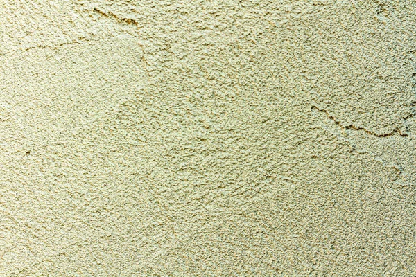 rough plaster facade painted yellow as a texture or background.