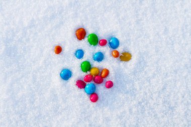 Çok renkli şekerler, karda sürükleyici. Karda şeker. Sevgililer Günü.