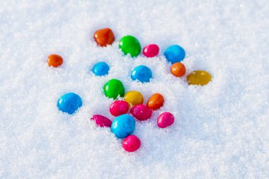 Çok renkli şekerler, karda sürükleyici. Karda şeker. Sevgililer Günü.