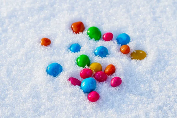 Çok renkli şekerler, karda sürükleyici. Karda şeker. Sevgililer Günü.