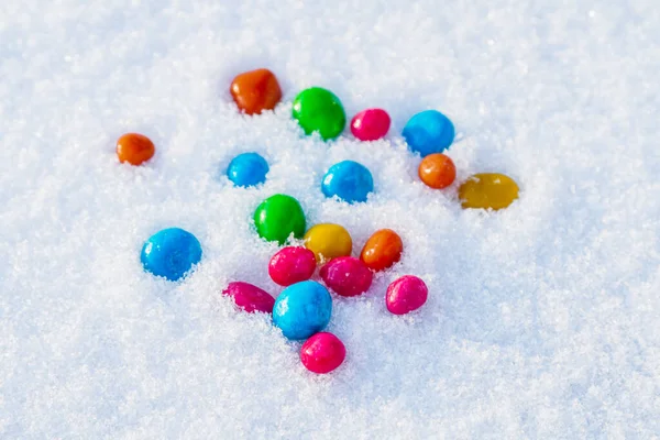 Çok renkli şekerler, karda sürükleyici. Karda şeker. Sevgililer Günü.