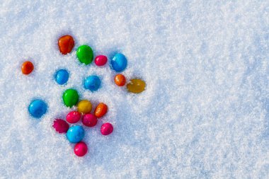 Çok renkli şekerler, karda sürükleyici. Karda şeker. Sevgililer Günü.