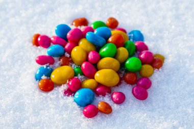 Çok renkli şekerler, karda sürükleyici. Karda şeker. Sevgililer Günü.