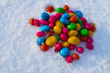 Çok renkli şekerler, karda sürükleyici. Karda şeker. Sevgililer Günü.