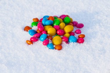 Çok renkli şekerler, karda sürükleyici. Karda şeker. Sevgililer Günü.