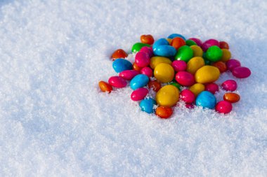 Çok renkli şekerler, karda sürükleyici. Karda şeker. Sevgililer Günü.