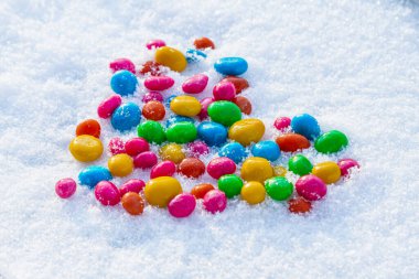 Karda çok renkli kalp şekilli şekerler. Karda şeker. Sevgililer Günü.