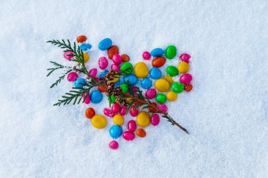 Karda çok renkli kalp şekilli şekerler. Karda şeker. Sevgililer Günü.