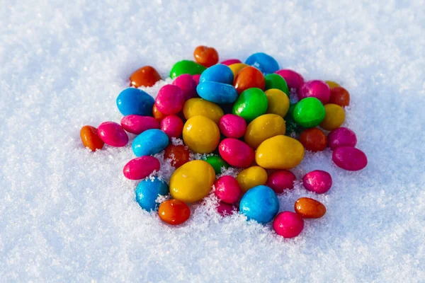 Çok renkli şekerler, karda sürükleyici. Karda şeker. Sevgililer Günü.