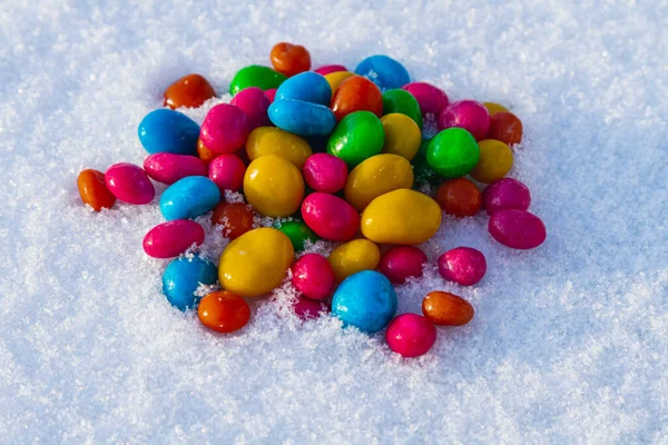 Çok renkli şekerler, karda sürükleyici. Karda şeker. Sevgililer Günü.