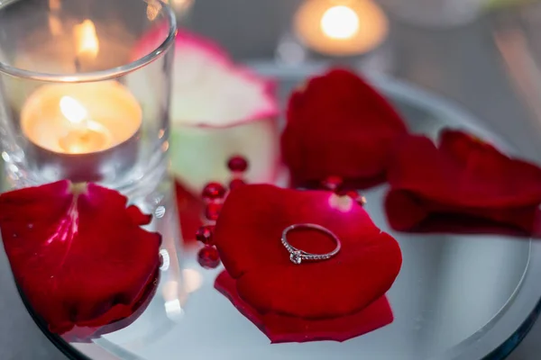 Obrączka Leży Czerwonych Płatkach Róż Tle Świec Oświadczyny Romantyczna Atmosfera — Zdjęcie stockowe