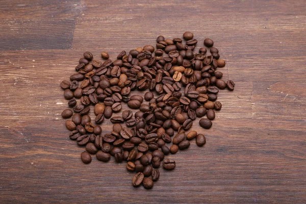 Kahverengi Ahşap Bir Masada Siyah Kahve Taneleri Yatıyor — Stok fotoğraf