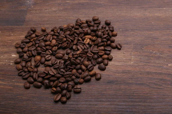 Svart Kaffekorn Ligger Brunt Trebord – stockfoto