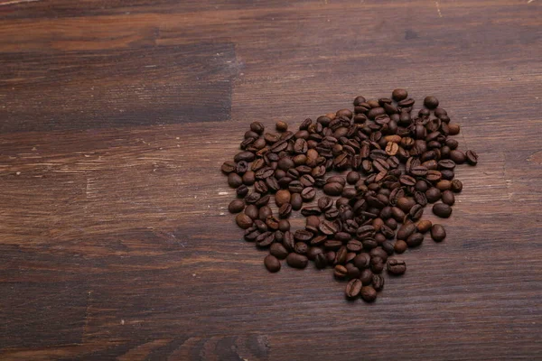 Black Coffee Grains Lie Brown Wooden Table — Stock Photo, Image