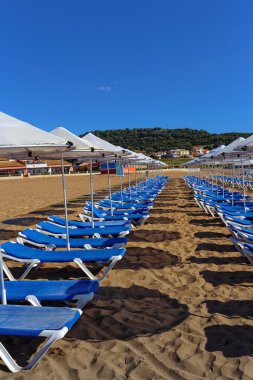 şezlong ve şemsiye kum plajındaki